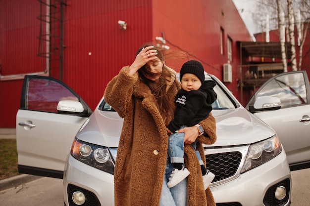 Jonge moeder en kind staan in de buurt van hun suv-auto Veiligheidsconcept