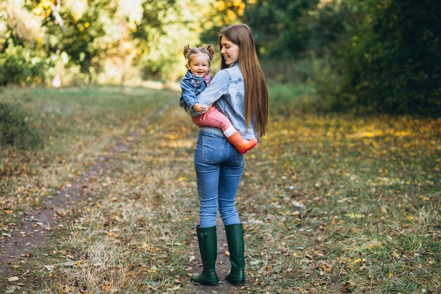 Jonge moeder met haar dochtertje in een herfst park