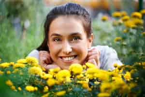 Gratis foto jonge mooie bloemist poseren, glimlachend onder bloemen.