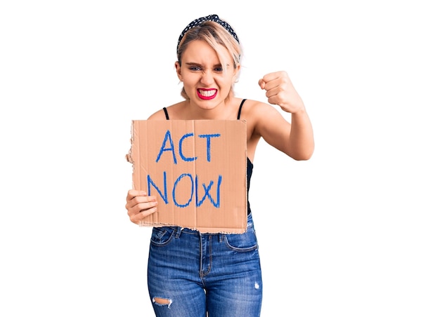 Gratis foto jonge mooie blonde vrouw met act nu banner geïrriteerd en gefrustreerd schreeuwend van woede, schreeuwend gek van woede en hand omhoog