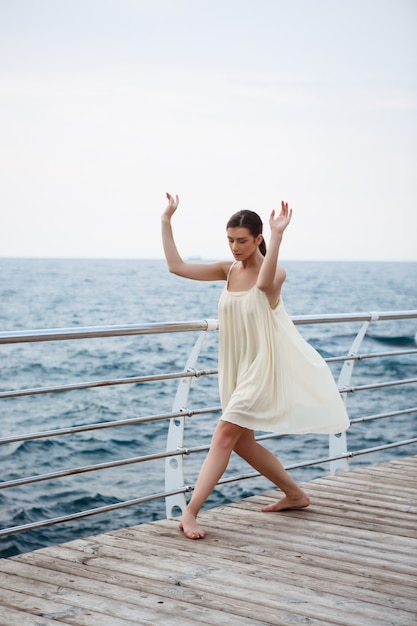 Jonge mooie en ballerina die buiten dansen stellen