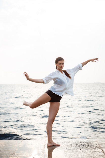 Jonge mooie en ballerina die buiten dansen stellen