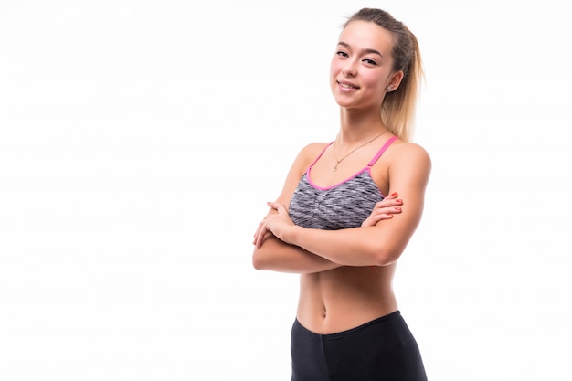 Jonge mooie fitness meisje toont haar sterke fit lichaam op wit