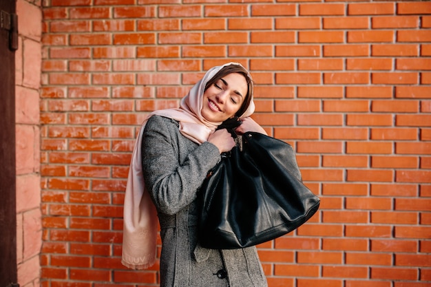 Jonge mooie gelukkige vrouw zeer tevreden met een nieuwe tas