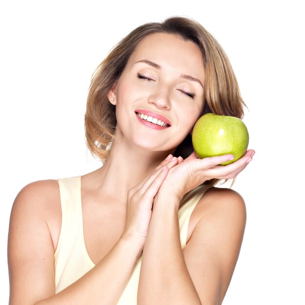 Jonge mooie glimlachende vrouw raakt de appel om onder ogen te zien geïsoleerd op wit.