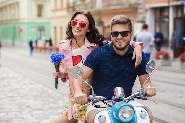 Jonge mooie hipster paar rijden op motor stadsstraat