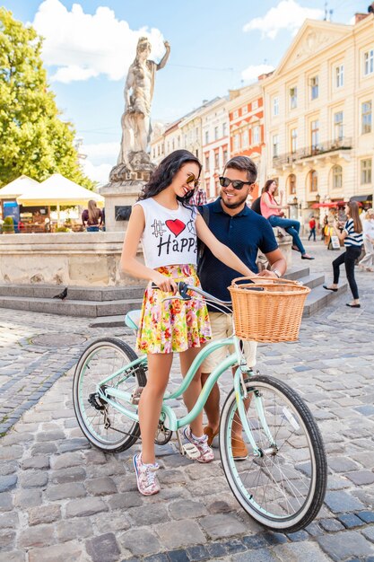 Jonge mooie hipster paar verliefd wandelen met fiets op oude stad straat