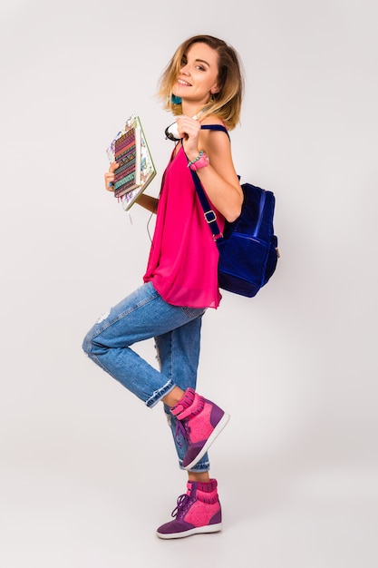 Jonge mooie hipster vrouw, roze schoenen en top holdingsboeken