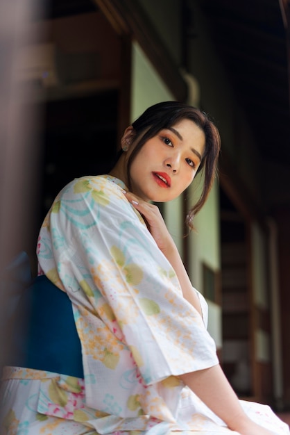 Gratis foto jonge mooie japanse vrouw die een traditionele kimono draagt