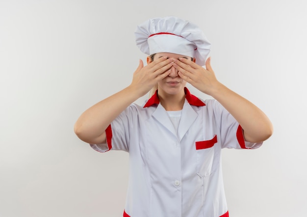 Jonge mooie kok in chef-kok uniforme ogen met handen sluiten