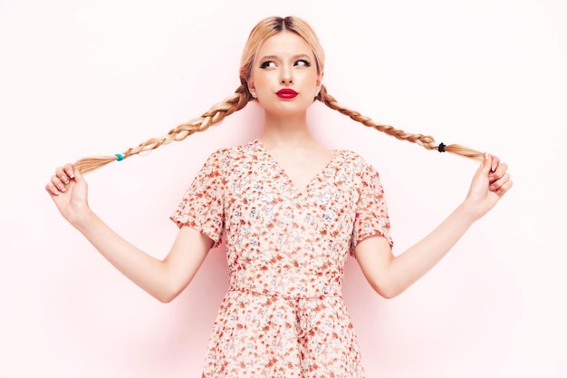 Jonge mooie lachende vrouw in trendy zomerjurk Sexy zorgeloze blonde vrouw poseren in de buurt van muur in studio Geschokt en verrast model plezier vrolijk en gelukkig in zonnebril geïsoleerd