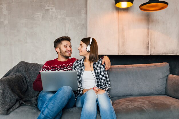 Jonge mooie man en vrouw om thuis te zitten in de winter kijken in laptop met verdrietig geschokt gezicht expressie, bang, enge film kijken op een datum, met behulp van internet, koppel samen op vrije tijd, daten