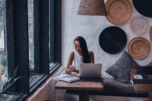 Gratis foto jonge mooie meid maakt gebruik van een laptop in het café, surfen op het internet