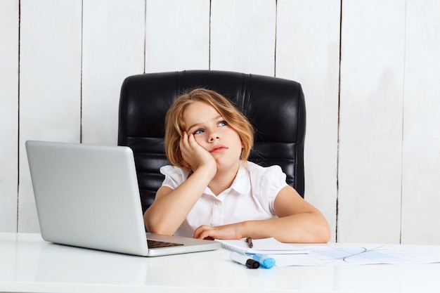 Gratis foto jonge mooie meisjeszitting op werkende plaats in bureau.