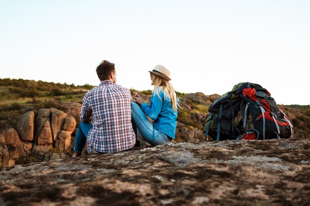 Jonge mooie paar reizigers genieten van uitzicht op canyon, glimlachend