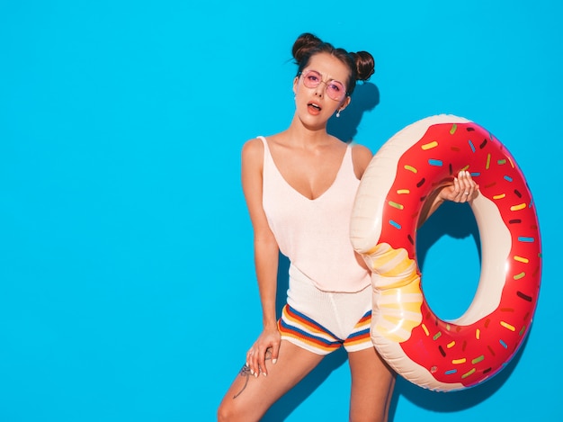 Jonge mooie sexy glimlachende hipster vrouw in zonnebril. met donut lilo opblaasbaar matras.