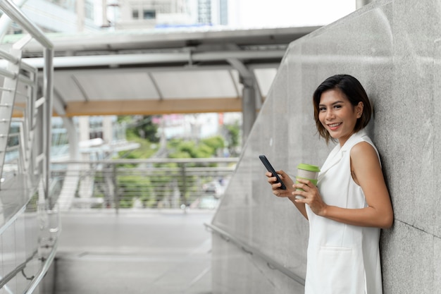 Jonge mooie smartphone van het vrouwengebruik in het openbaar