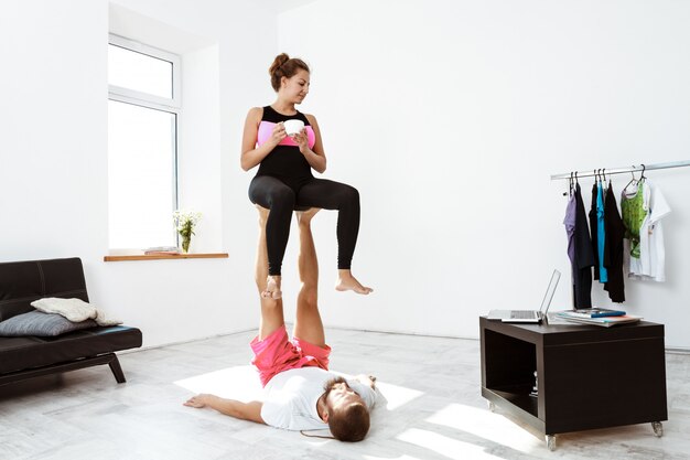 Jonge mooie sportieve paar asana training yoga thuis.