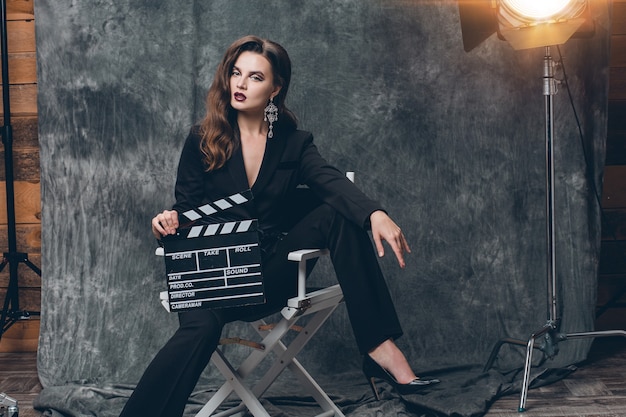 Jonge mooie stijlvolle sexy vrouw op bioscoop backstage, film klepel te houden