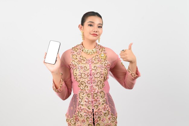 Jonge mooie vrouw aankleden in de lokale cultuur in de zuidelijke regio poseren met smartphone