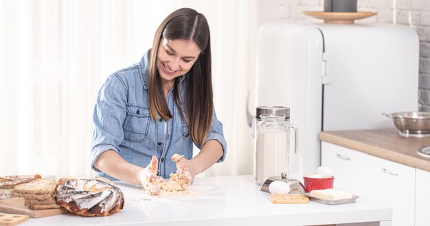 jonge mooie vrouw bereidt zelfgemaakte taarten in de keuken.