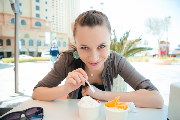 Jonge mooie vrouw die roomijs eet