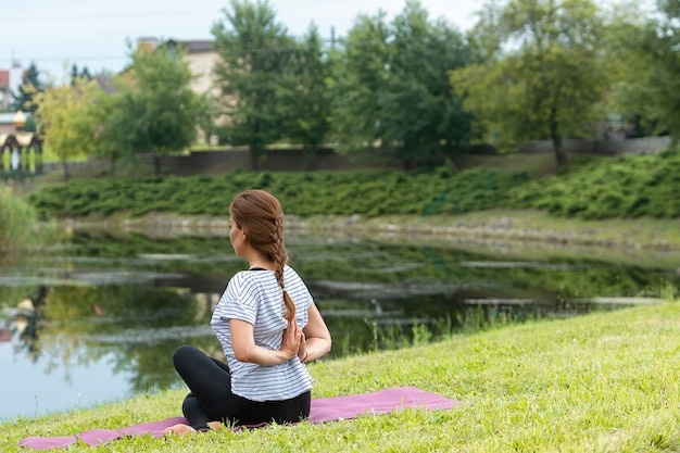 Jonge mooie vrouw doet yoga oefening in groen park