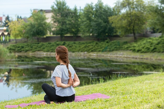 Jonge mooie vrouw doet yoga oefening in groen park