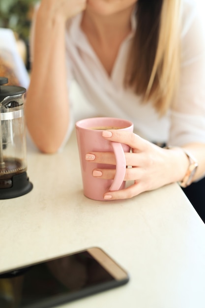 Jonge mooie vrouw, drinken koffie of thee