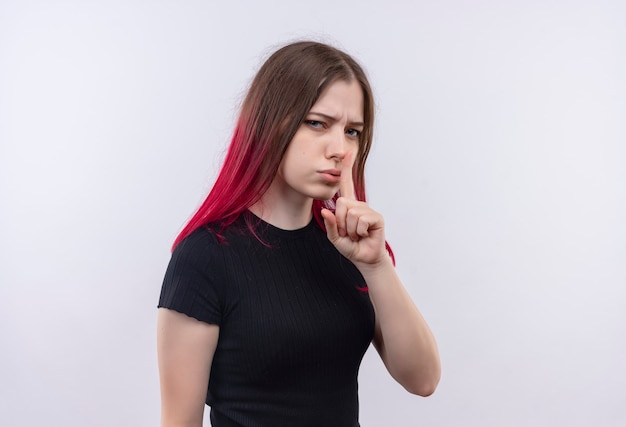 Jonge mooie vrouw, gekleed in zwart t-shirt met stilte gebaar op geïsoleerde witte muur