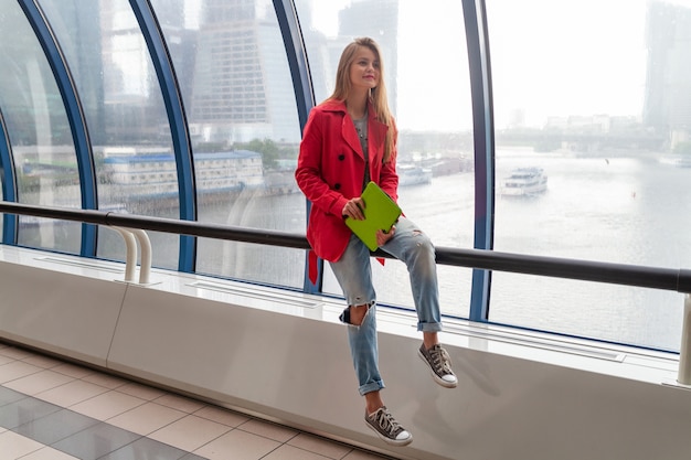 Jonge mooie vrouw in casual de tabletlaptop van de uitrustingsholding in stedelijk gebouw