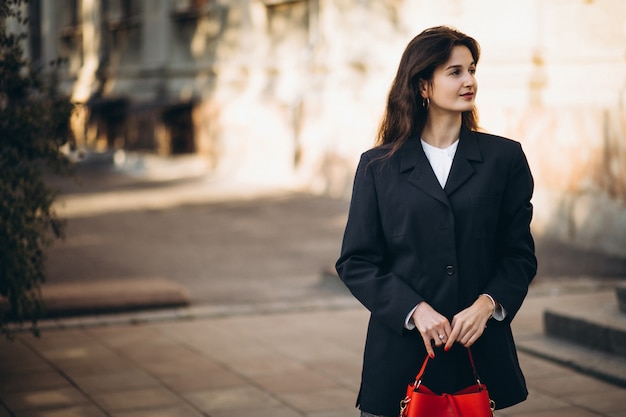 Jonge mooie vrouw in stijlvolle outfit in een herfst straat