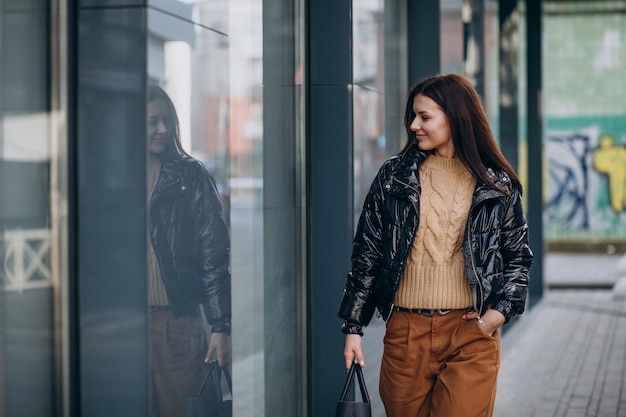 Gratis foto jonge mooie vrouw in warm jasje in openlucht