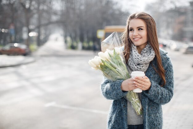 Jonge mooie vrouw met bloemen buiten