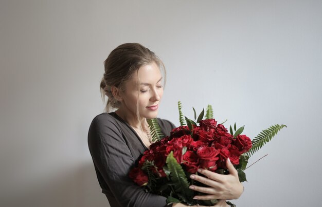 Jonge mooie vrouw met rode rozen