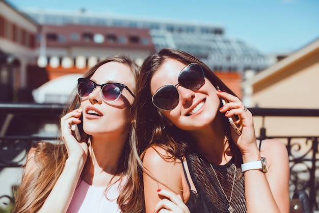 Jonge mooie vrouw poseren in de straat met de telefoon