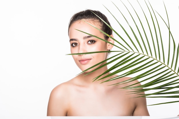 Jonge mooie vrouw poseren met groene palmblad