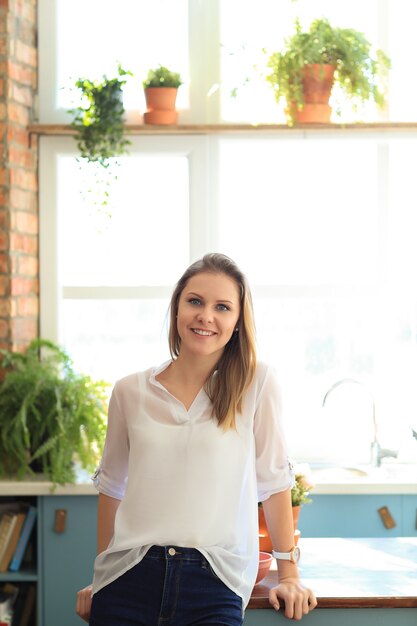 Jonge mooie vrouw thuis met planten