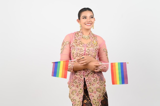 Jonge mooie vrouw verkleedt zich in de lokale cultuur in de zuidelijke regio met regenboogvlag