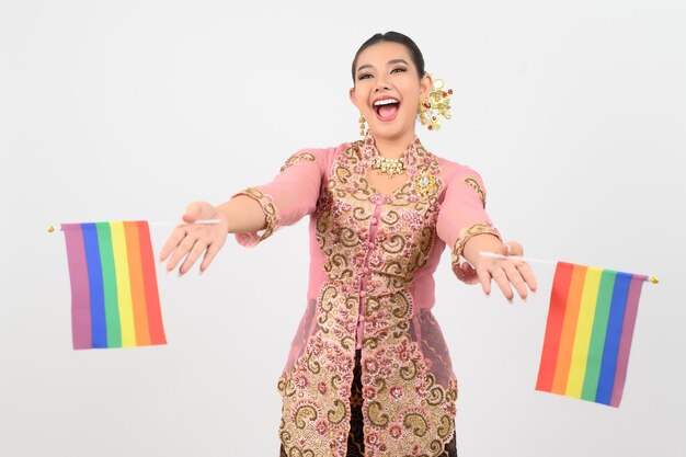 Jonge mooie vrouw verkleedt zich in de lokale cultuur in de zuidelijke regio met regenboogvlag