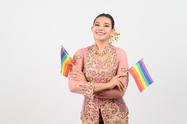Jonge mooie vrouw verkleedt zich in de lokale cultuur in de zuidelijke regio met regenboogvlag
