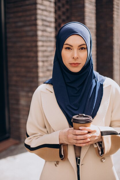 Jonge moslimvrouw die koffie drinkt