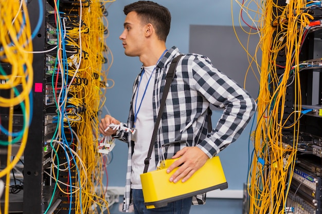 Jonge netwerkingenieur die ethernet schakelaars bekijkt