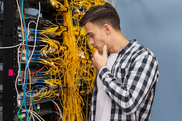 Jonge netwerkingenieur op het middelgrote schot van de serverruimte