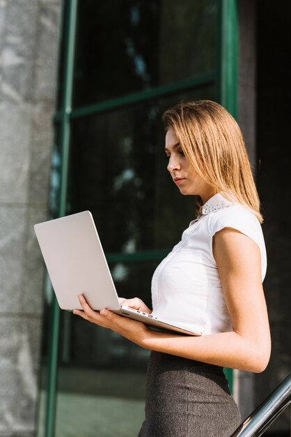 Jonge onderneemster die laptop met behulp van in openlucht