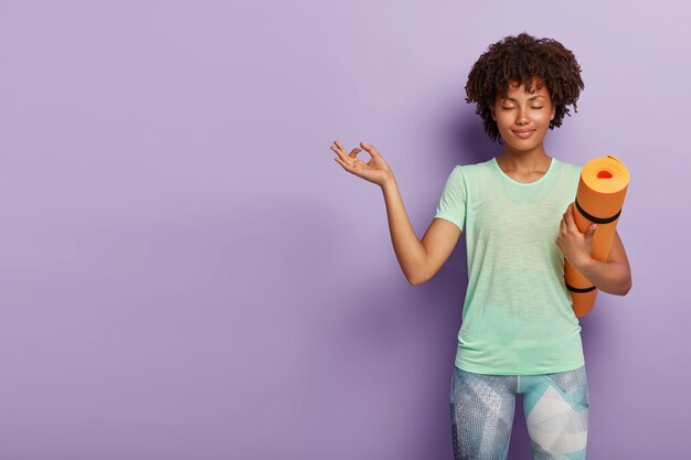 Jonge ontspannen vrouw beoefent yoga met karemat