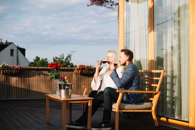 Jonge paarzitting in dakrestaurant het drinken wijn