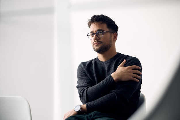 Jonge radeloze man die wacht op de start van een groepstherapie