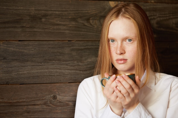 Gratis foto jonge roodharige vrouw in café