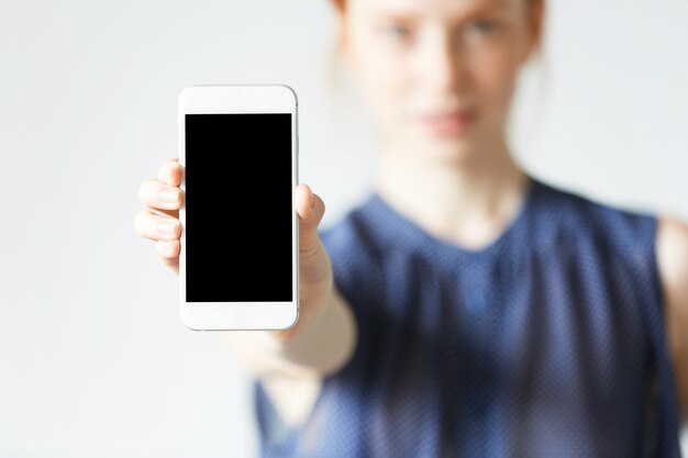 Jonge roodharige vrouw met smartphone